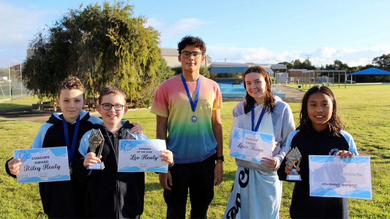 Award recipients holding up their certificates, trophies and medallions